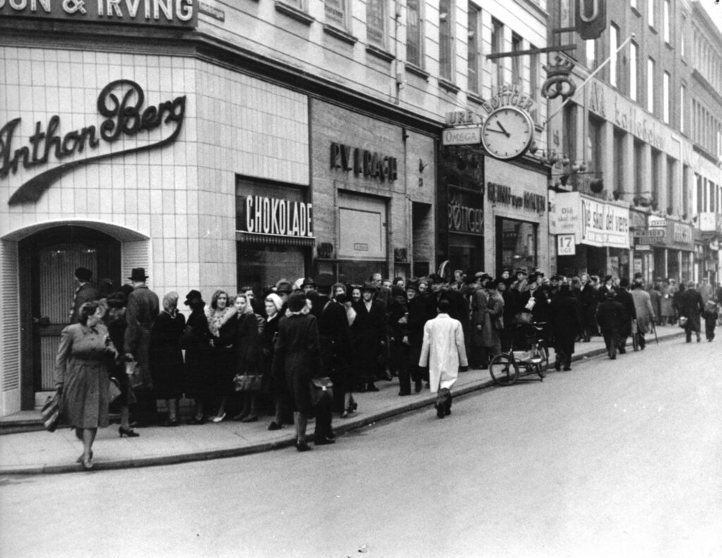 Anthon Berg Schokoladenladen, vor dem eine lange Schlange von Menschen wartet, um das Geschäft zu betreten.