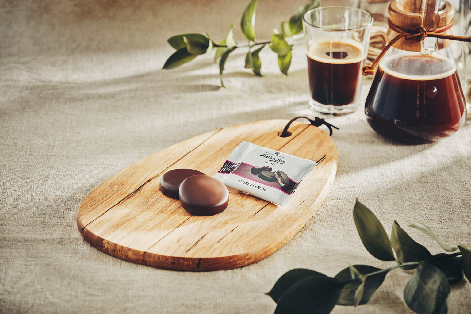 Ein Holz-Schneidebrett, auf dem zwei Cherry in Rum Praline liegen.